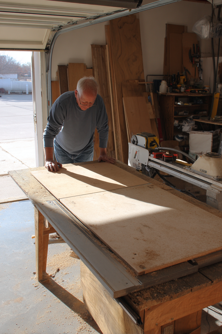 A sharp carbide table saw blade installed on a woodworking saw in a clean garage workshop before making a rip cut